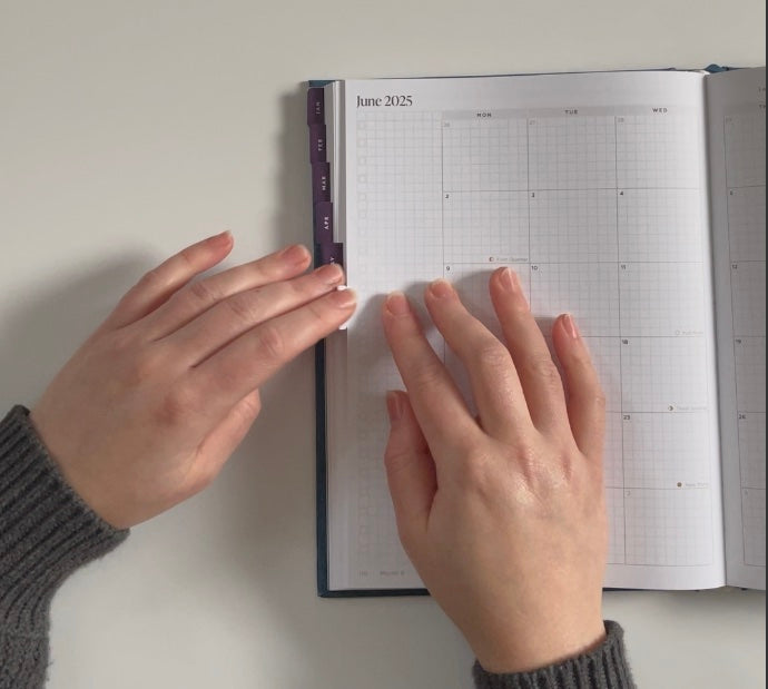 Hemlock and Oak monthly tabs being attached to a planner