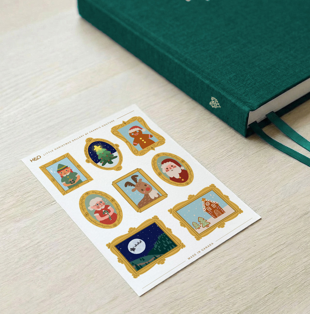 Little Christmas Gallery sticker sheet by Frankie Couture shown beside a notebook with one of the stickers applied