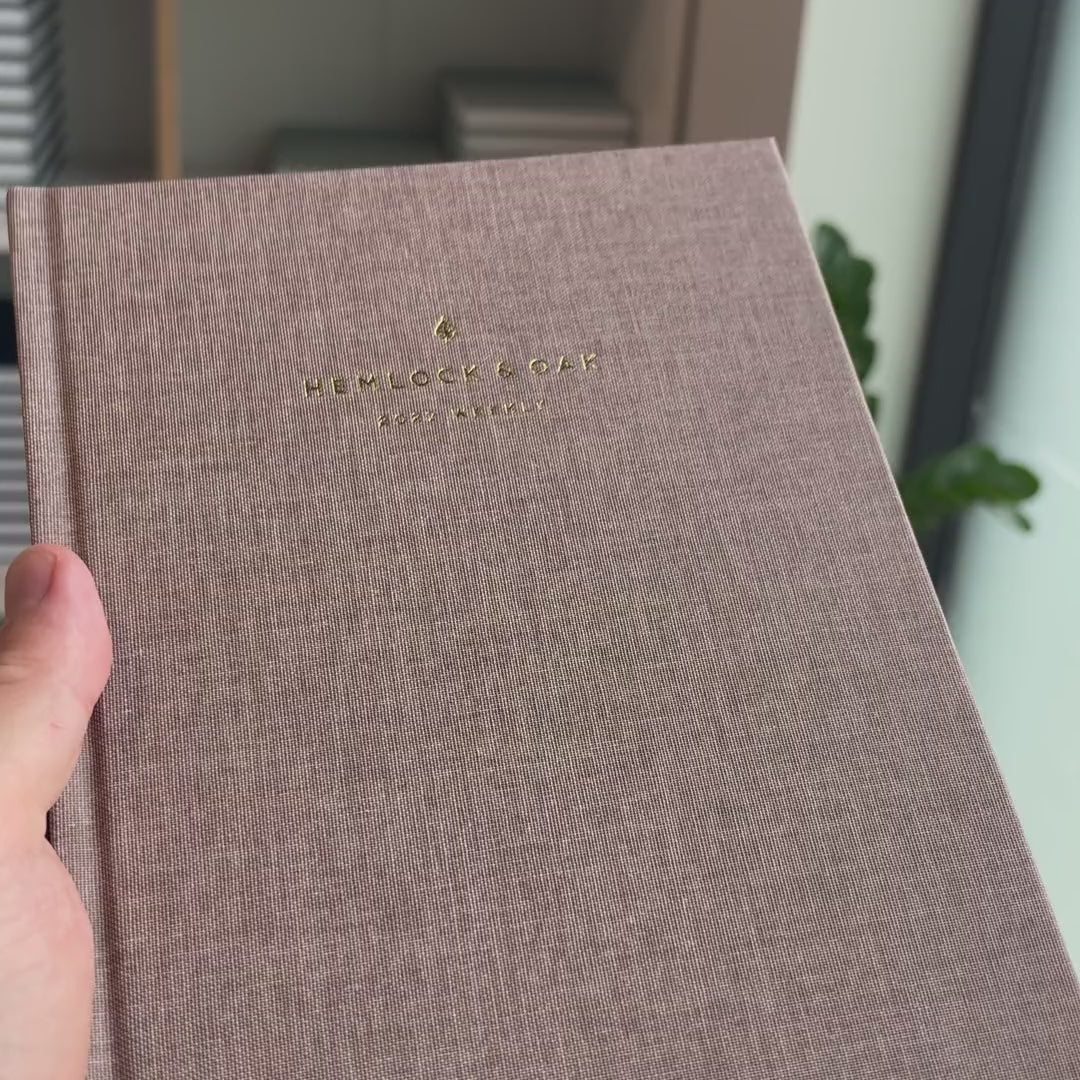 2027 Weekly Planner (Hardcover, Vertical, Heritage 120gsm, A5+) in Fawn, held in hand #color_fawn