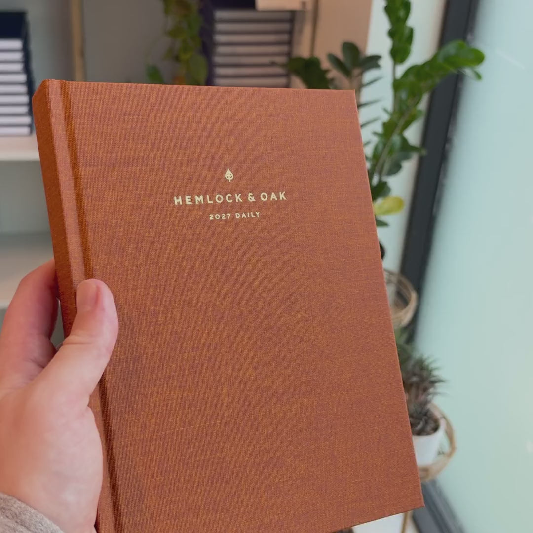 2027 Signature Daily Planner (Hardcover, A5+, Archivist 70gsm) in Autumnal, held in hand #color_autumnal