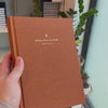 2027 Signature Daily Planner (Hardcover, A5+, Archivist 70gsm) in Autumnal, held in hand #color_autumnal