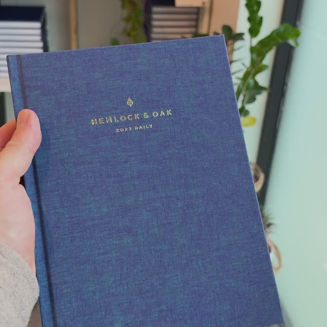2027 Signature Daily Planner (Hardcover, A5+, Archivist 70gsm) in Wild Indigo, held in hand #color_wild indigo