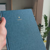 2027 B5 Minimalist Vertical Planner (Hardcover, Heritage 120gsm) in Rivière, held in hand #color_riviere #color_rivière