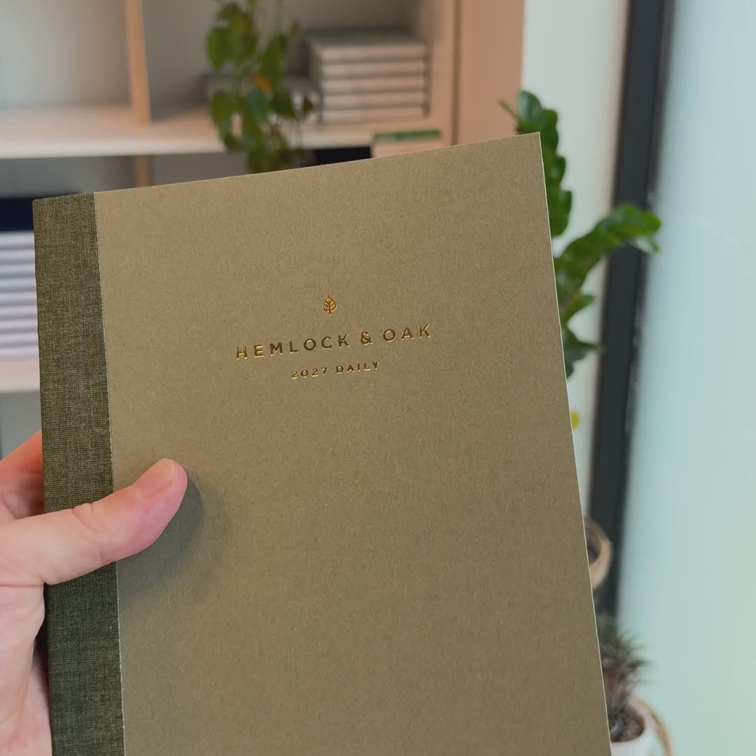 2027 Signature Daily Planner (Paper Flex, A5+, Archivist 70gsm) in Moss, held in hand #color_moss