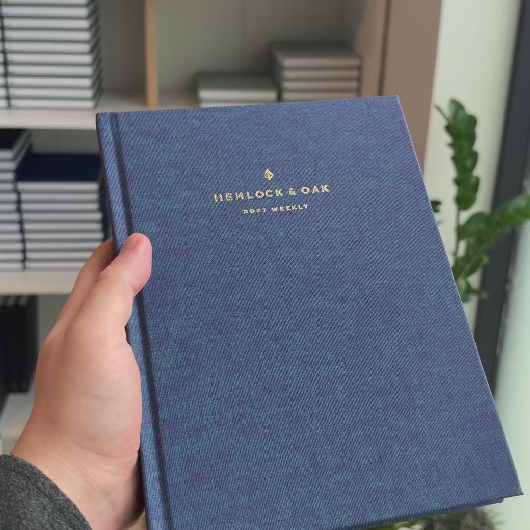 2027 Sunday Start Weekly Planner (Hardcover, Vertical, Heritage 120gsm, A5+) in Wild Indigo, held in hand #color_wild indigo