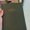 2027 Signature Daily Planner (Hardcover, A5+, Archivist 70gsm) in Woodlands, held in hand #color_woodlands
