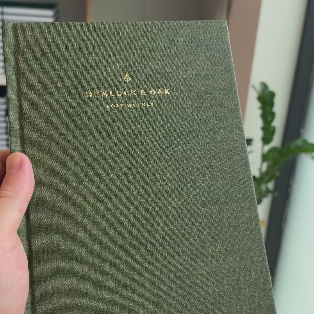 2027 Sunday Start Weekly Planner (Hardcover, Vertical, Heritage 120gsm, A5+) in Moss, held in hand #color_moss
