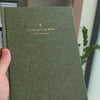 2027 Sunday Start Weekly Planner (Hardcover, Vertical, Heritage 120gsm, A5+) in Moss, held in hand #color_moss