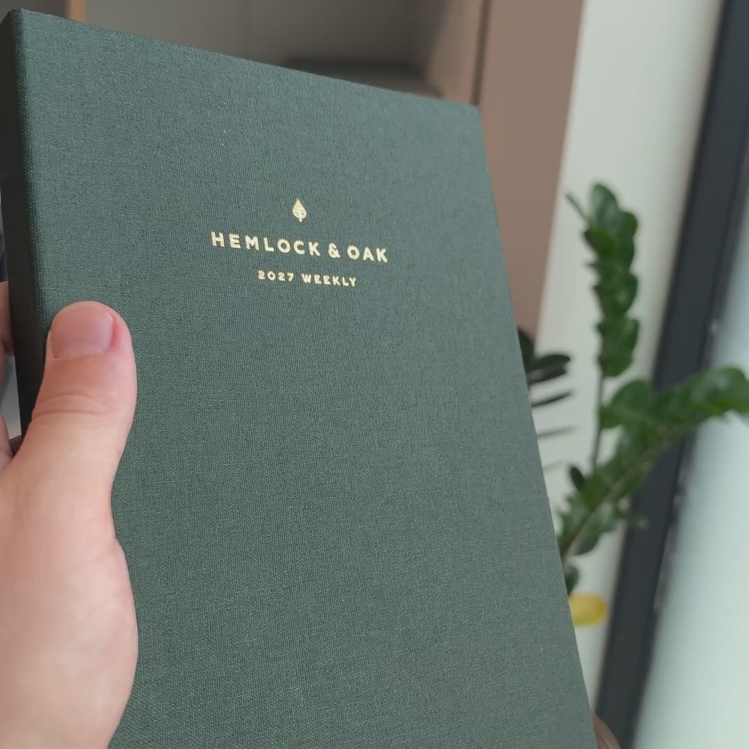 2027 Sunday Start Weekly Planner (Cloth Flex, Heritage 120gsm, A5+) in Woodlands, held in hand #color_woodlands