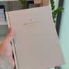 2027 Signature Daily Planner (Hardcover, A5+, Archivist 70gsm) in Natural Pearl, held in hand #color_natural pearl