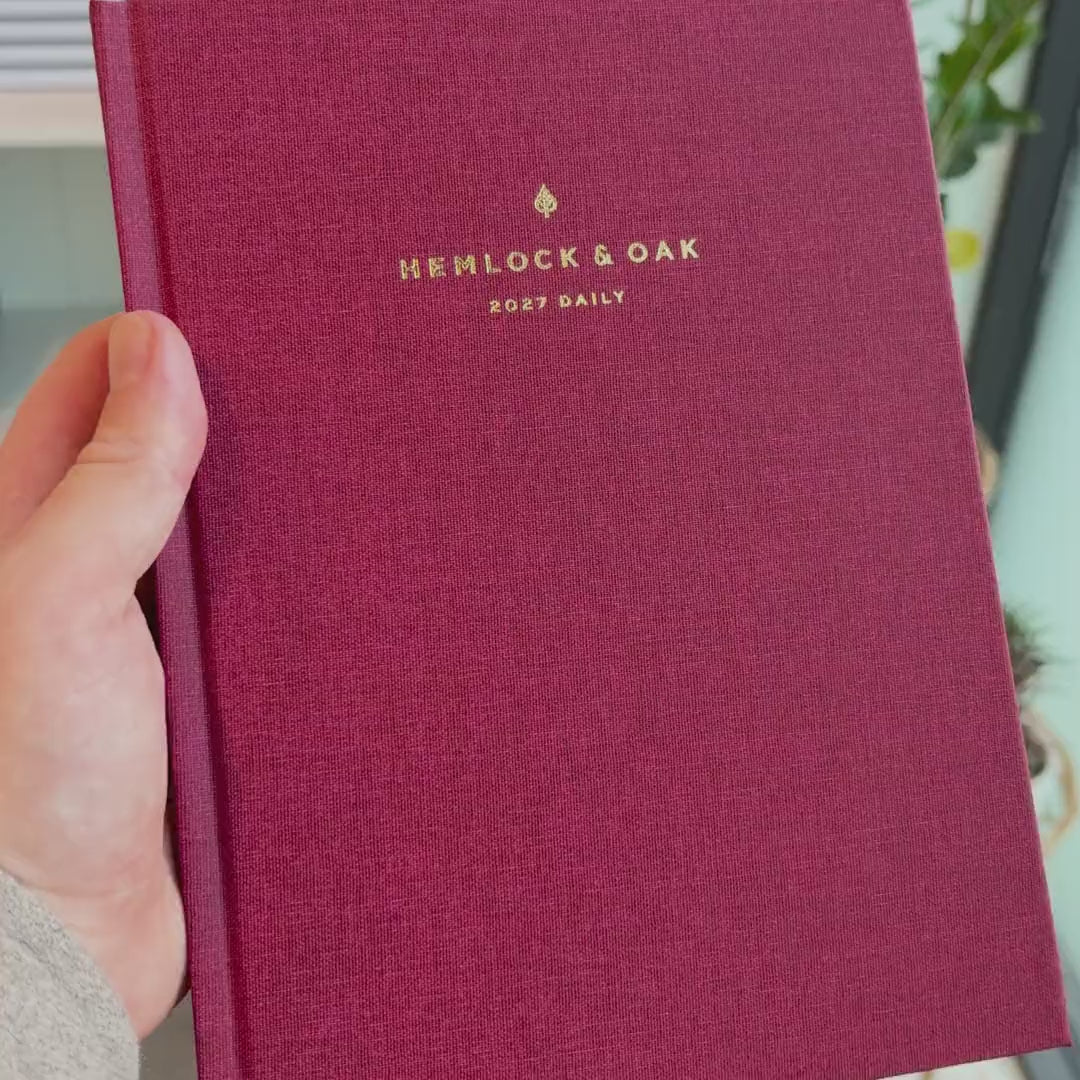 2027 Signature Daily Planner (Hardcover, A5+, Archivist 70gsm) in Scarlet Oak, held in hand #color_scarlet oak