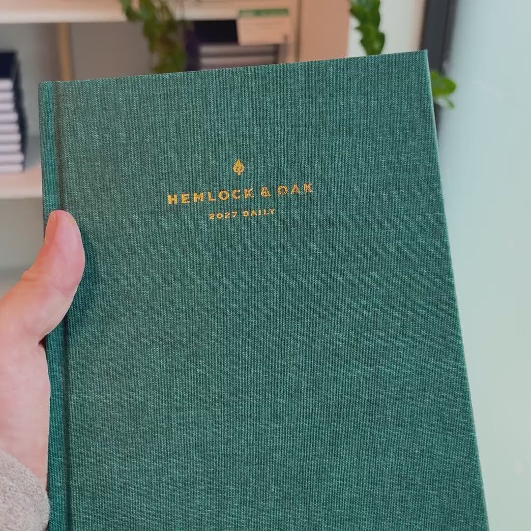 2027 Signature Daily Planner (Hardcover, A5+, Archivist 70gsm) in Enchanted Forest, held in hand #color_enchanted forest