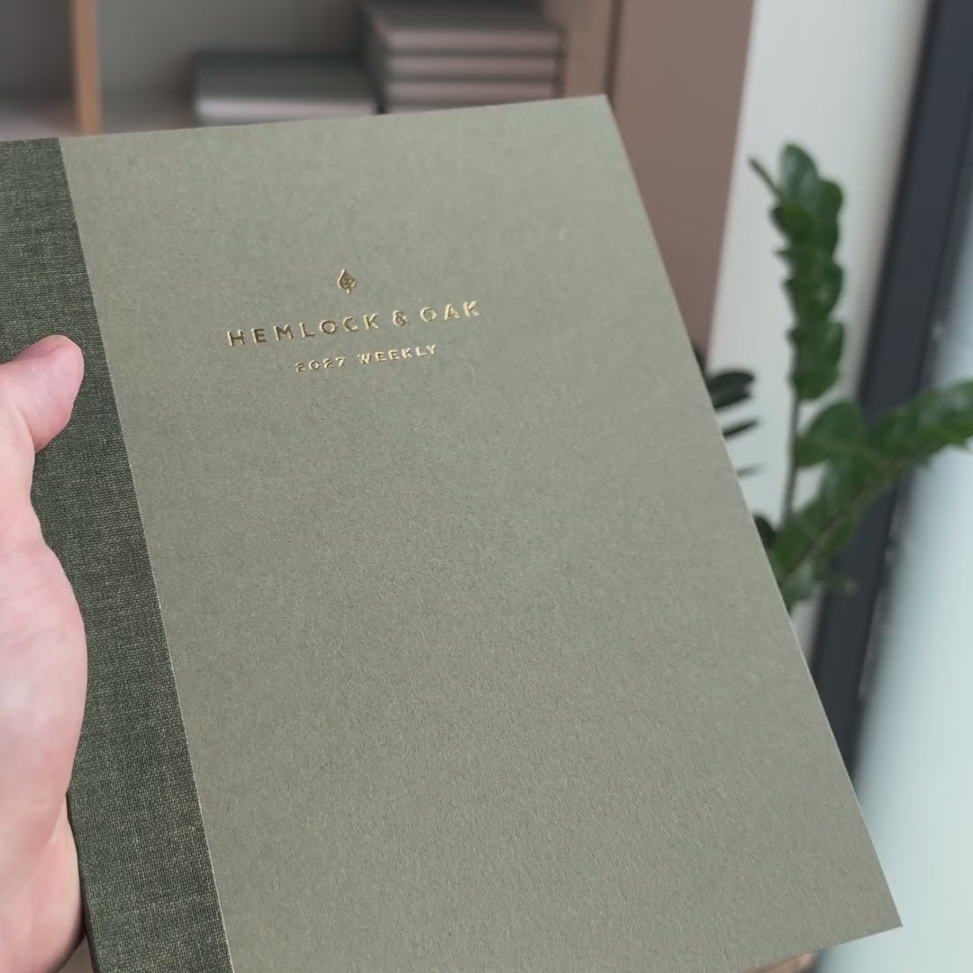 2027 Sunday Start Weekly Planner (Paper Flex, Heritage 120gsm, A5+) in Moss, held in hand #color_moss