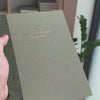 2027 Weekly Planner (Paper Flex, Heritage 120gsm, A5+) in Moss, held in hand #color_moss