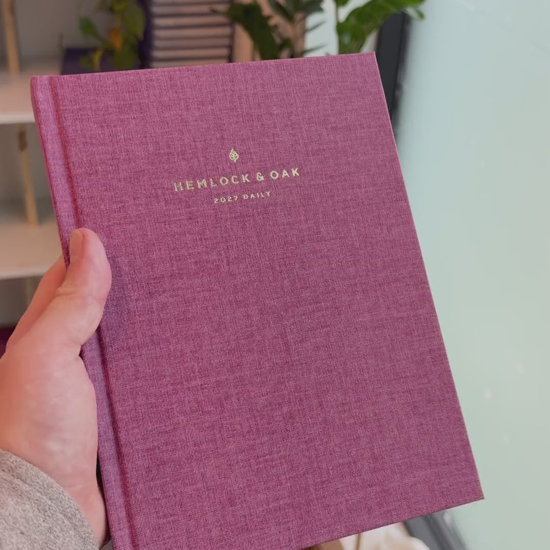 2027 Signature Daily Planner (Hardcover, A5+, Archivist 70gsm) in Wild Rose, held in hand #color_wild rose