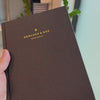 2027 Signature Daily Planner (Hardcover, A5+, Archivist 70gsm) in Charbon, held in hand #color_charbon
