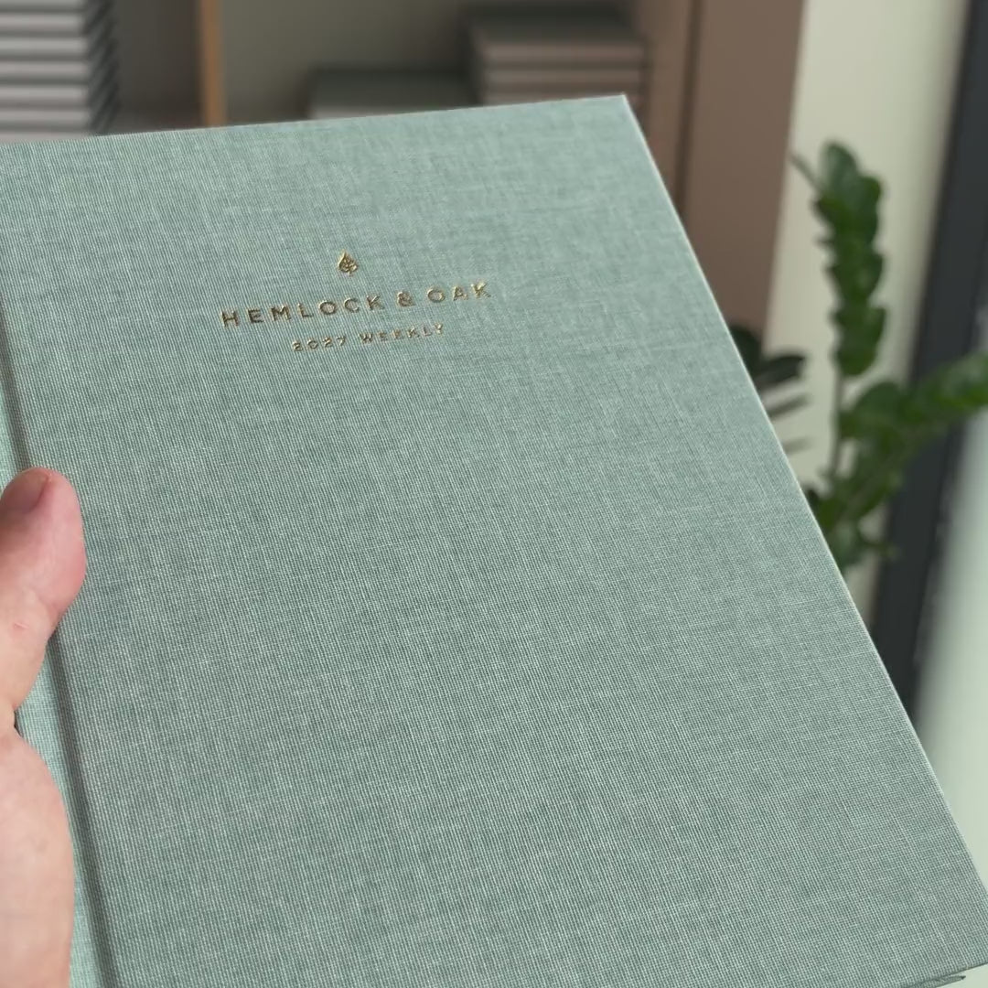 2027 Sunday Start Weekly Planner (Hardcover, Vertical, Heritage 120gsm, A5+) in Moonflower, held in hand #color_moonflower