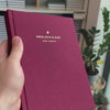 2027 Sunday Start Weekly Planner (Hardcover, Vertical, Heritage 120gsm, A5+) in Mulberry, held in hand #color_mulberry