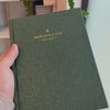 2027 Signature Daily Planner (Hardcover, A5+, Archivist 70gsm) in Mystic Forest, held in hand #color_mystic forest