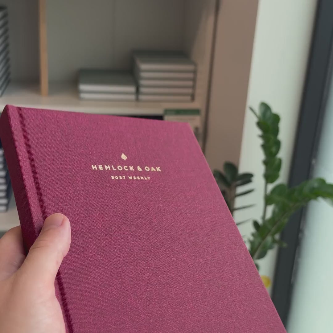 2027 Sunday Start Weekly Planner (Hardcover, Vertical, Heritage 120gsm, A5+) in Scarlet Oak, held in hand #color_scarlet oak